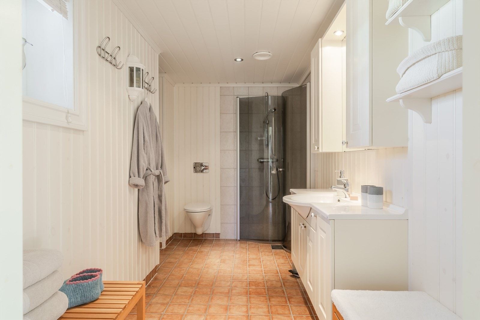 Badet er på 7 m² og fremstår funksjonelt med panel på vegger og i himling. Gulvet er flislagt og utstyrt med varmekabler, noe som gir økt komfort i hverdagen. Galleribilde
