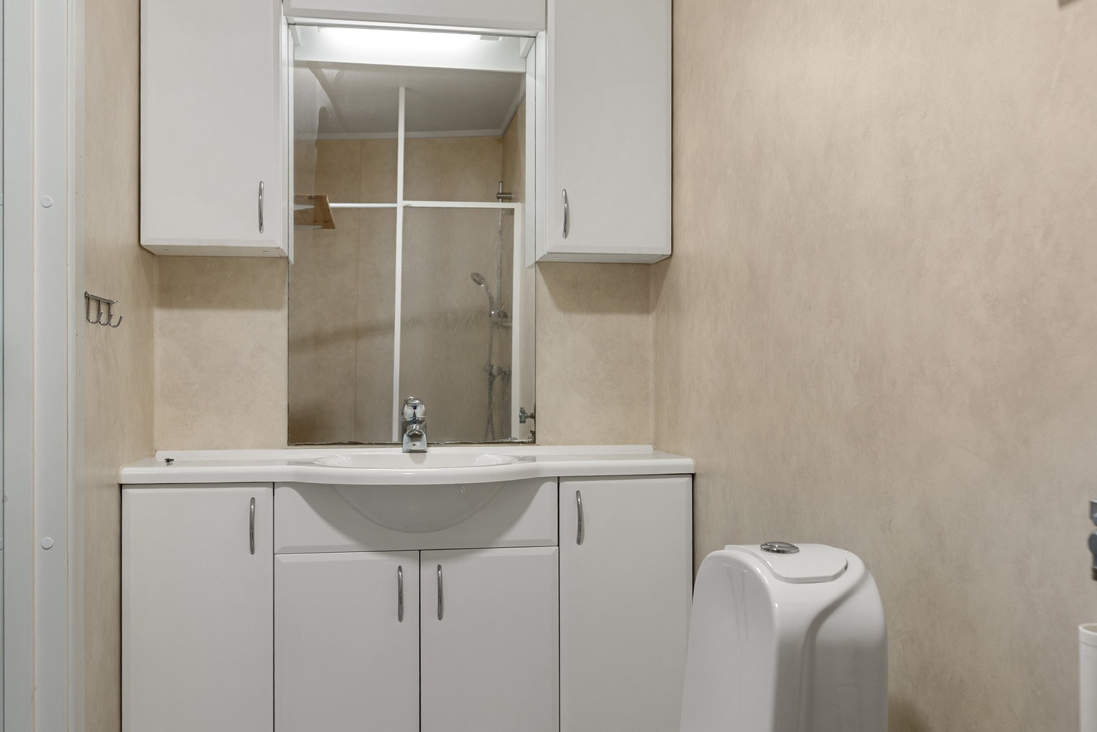 Badet er utstyrt med dusj, servant, WC, opplegg for vaskemaskin og varmekabler i gulvet. Galleribilde