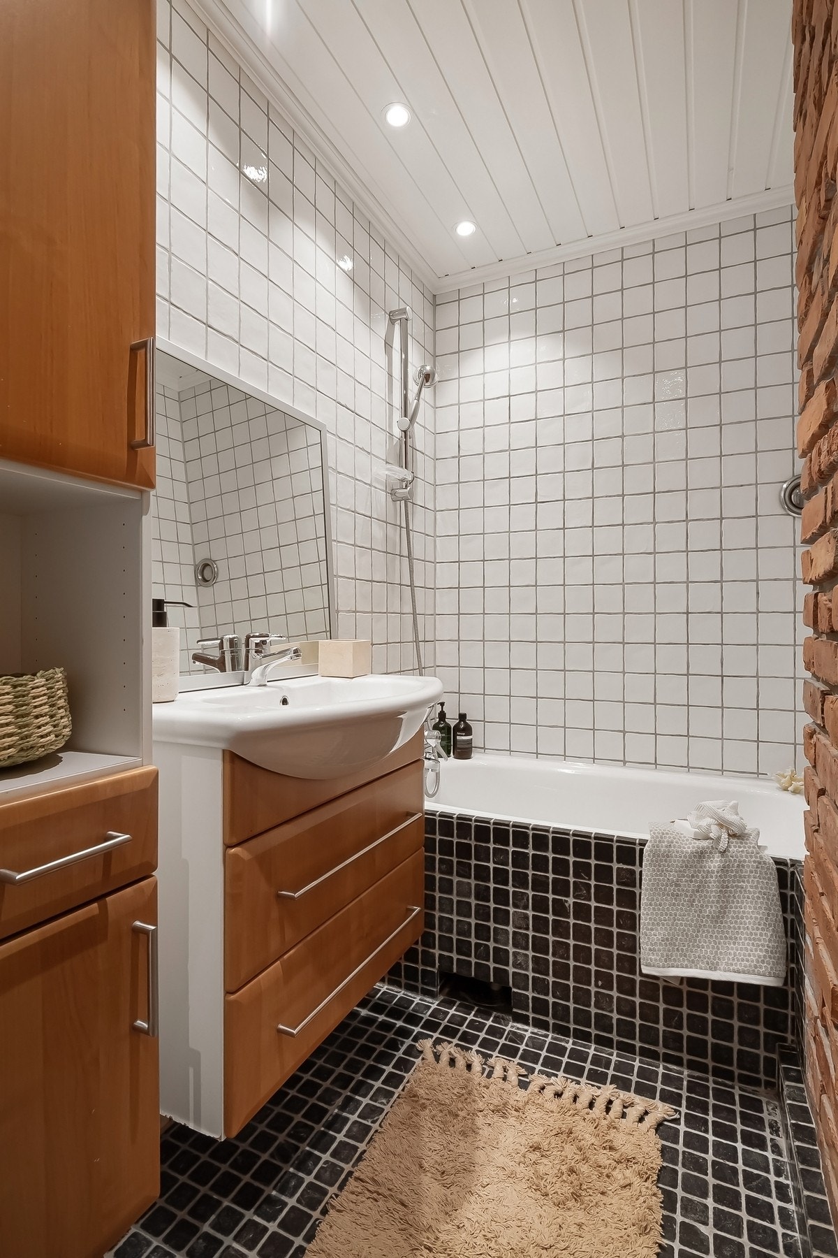 Badet har varmekabler i gulvet og er utstyrt med servantskap og speil på vegg over servant. Videre finner du innebygd badekar med dusjutstyr, toalett og elektrisk avtrekk. Galleribilde
