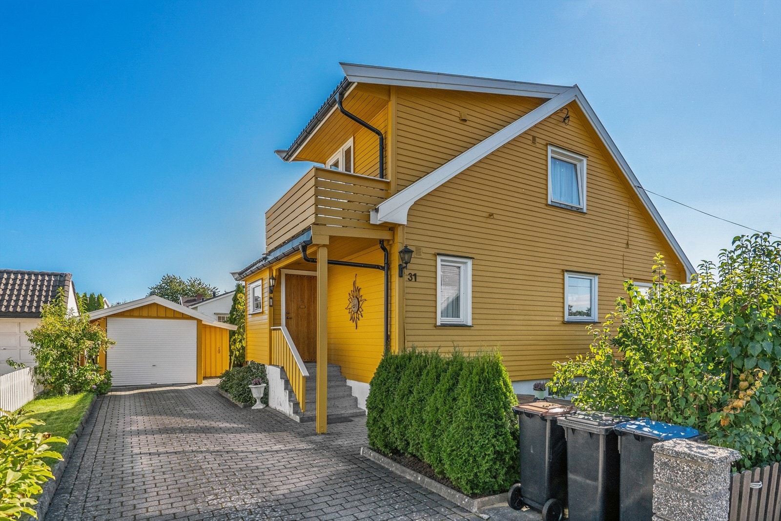 Stor steinbelagt gårdsplass med enkel garasje. Galleribilde