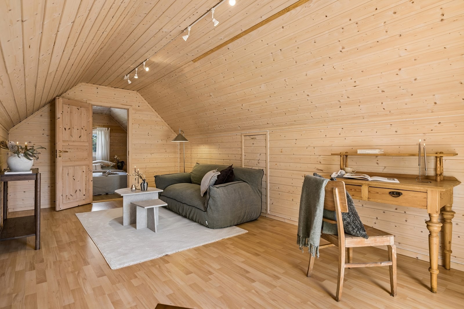Loftstue/anneksrom med lyse treoverflater og god gulvplass. Arealet i garasje/anneks er ikke godkjent som rom for varig opphold. Galleribilde