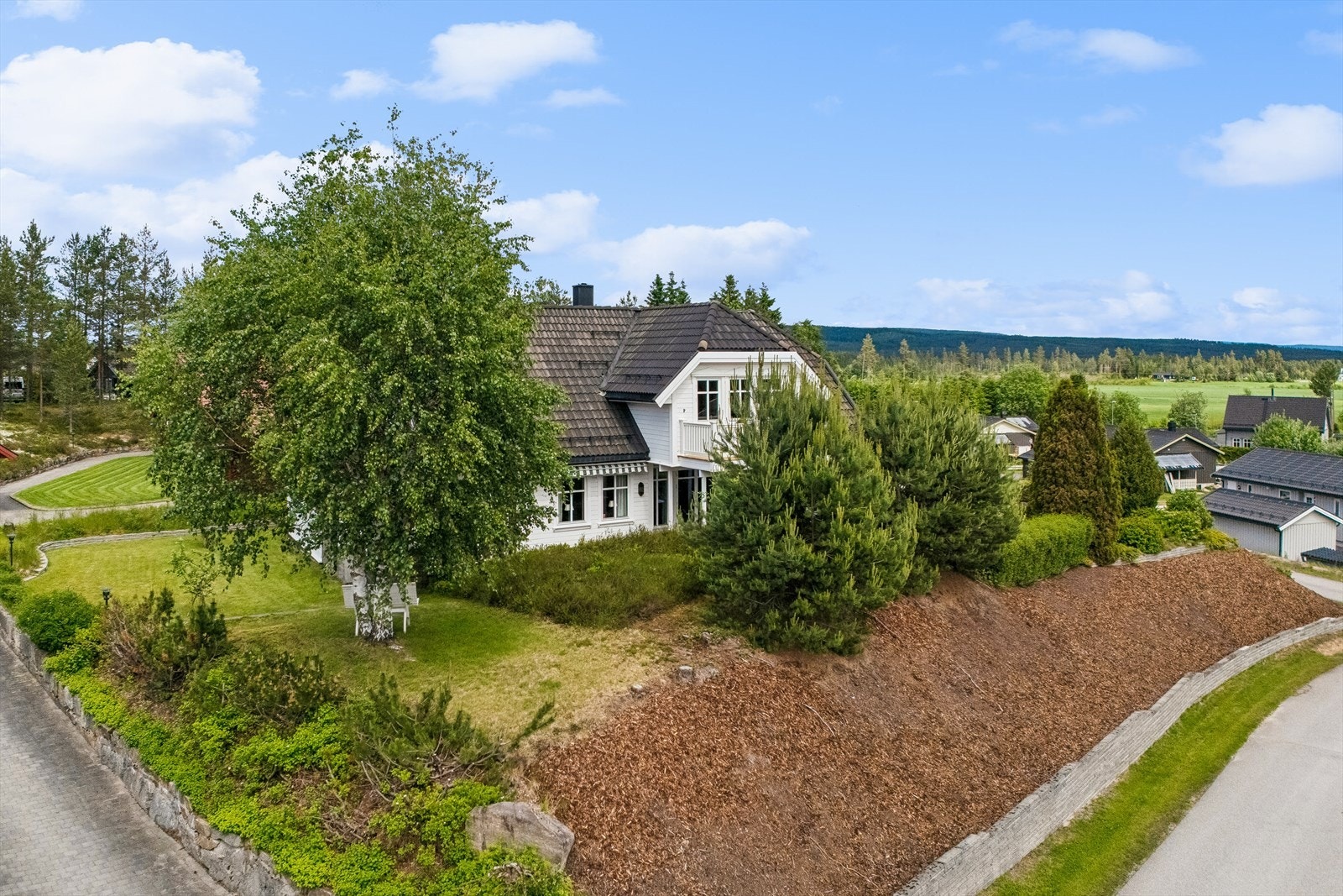 Luftfoto som viser den opparbeidede hagen, beplantningen og plasseringen i boligområdet. Galleribilde
