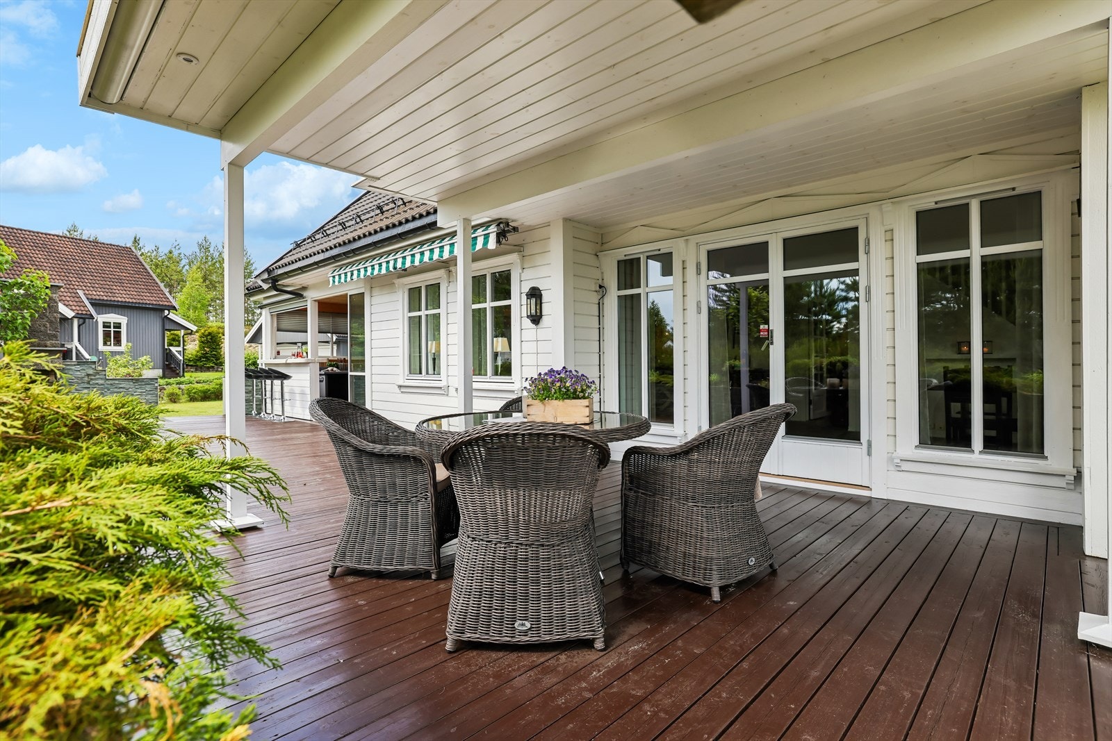 Overbygget terrasse med god plass til spisegruppe og avslapping tett på hagen. Galleribilde