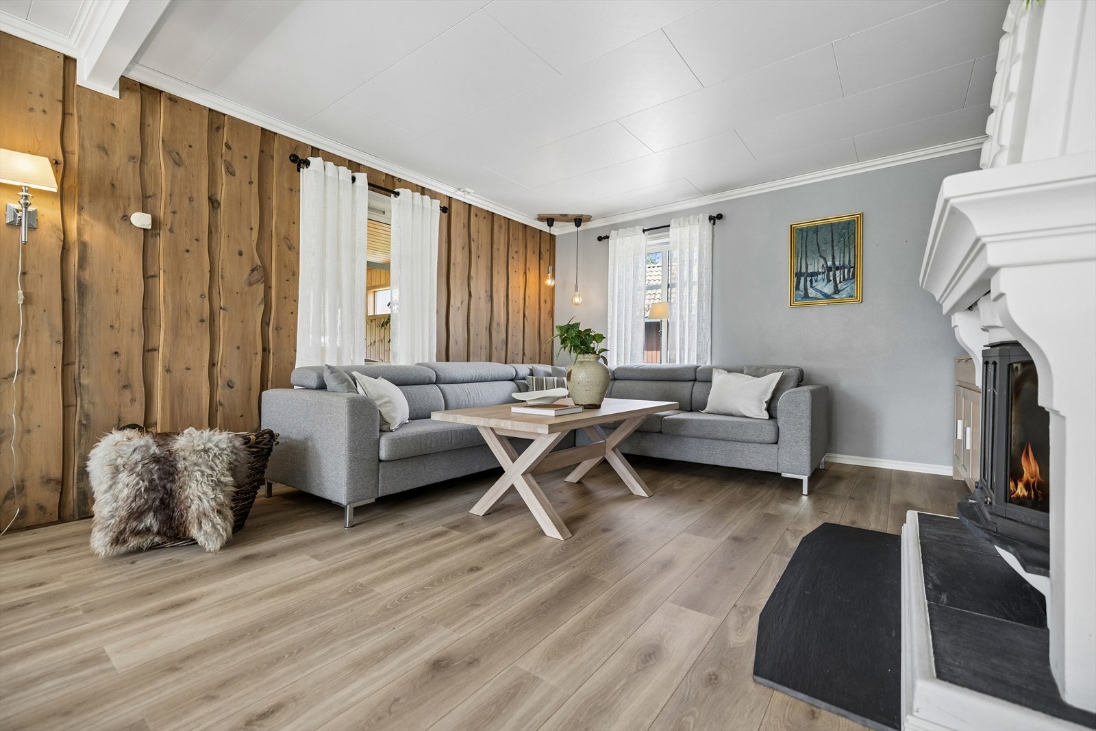 Stuen har lyse gulvflater, panelhimling og en lun peisplass. Galleribilde