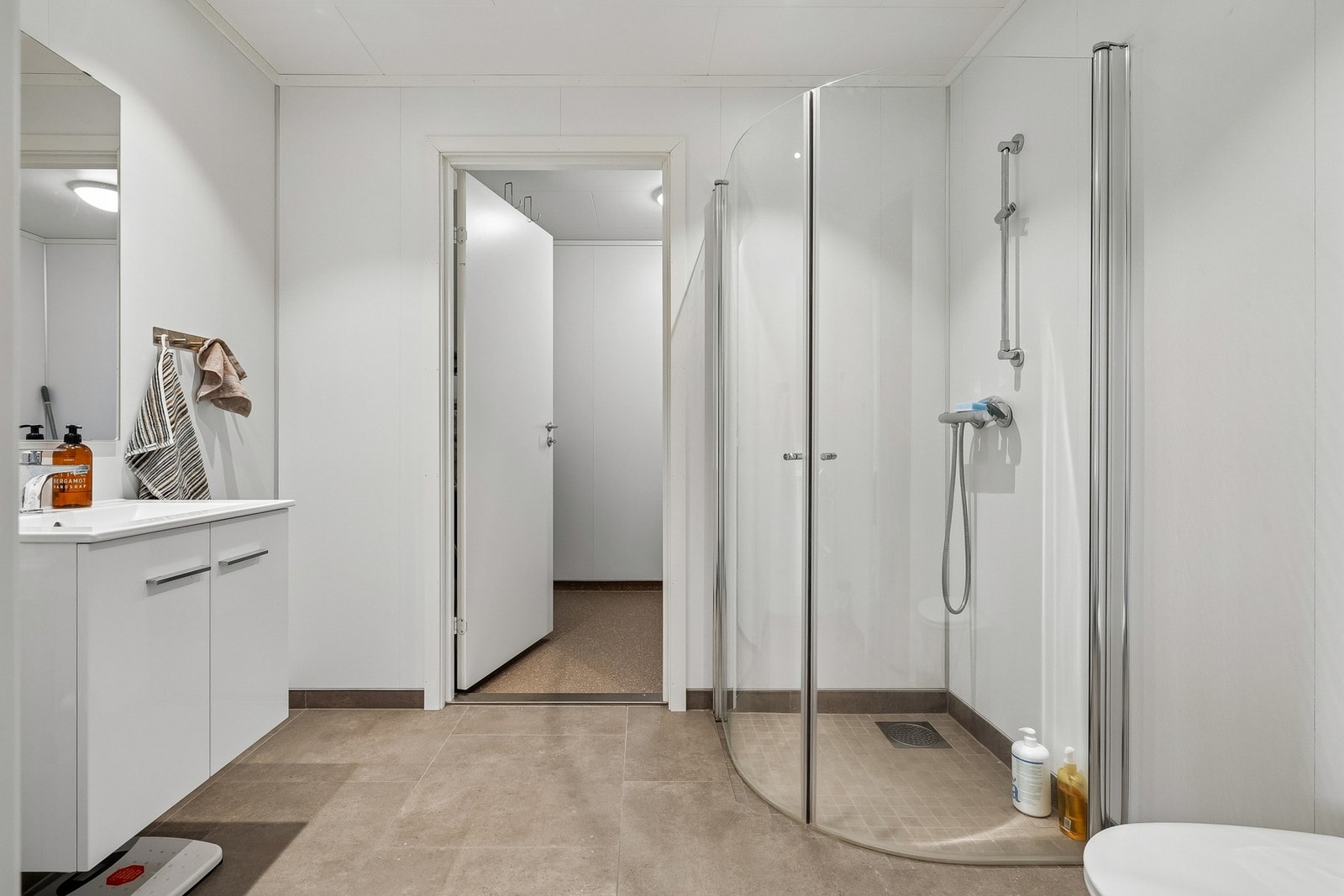 Badet har flislagt gulv med vannbåren gulvvarme og baderomsplater på veggene. Galleribilde