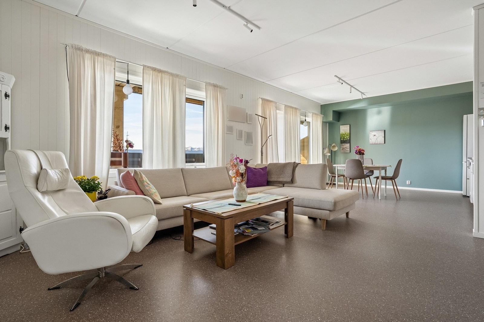 Stuen har en åpen løsning mot kjøkkenet, med god plass til både sofagruppe og spisebord. Galleribilde