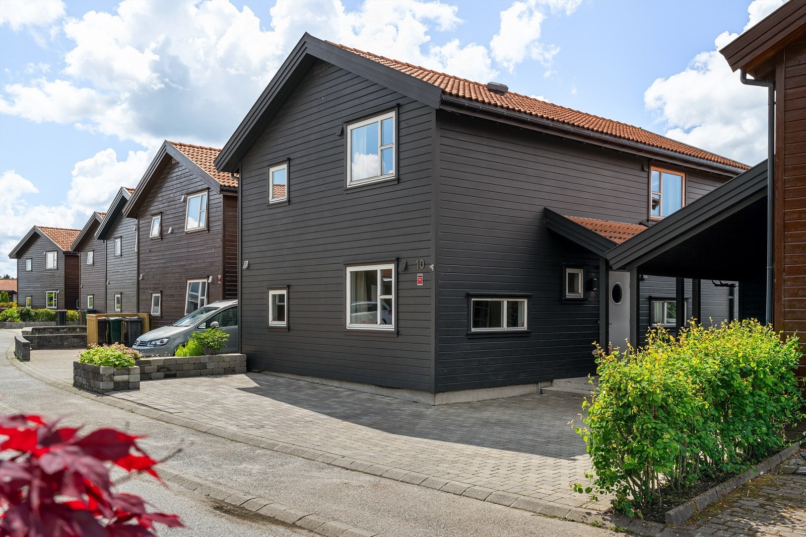 Innbydende og velholdt enebolig med moderne uttrykk, carport med elbillader og opparbeidet gårdsplass. Galleribilde