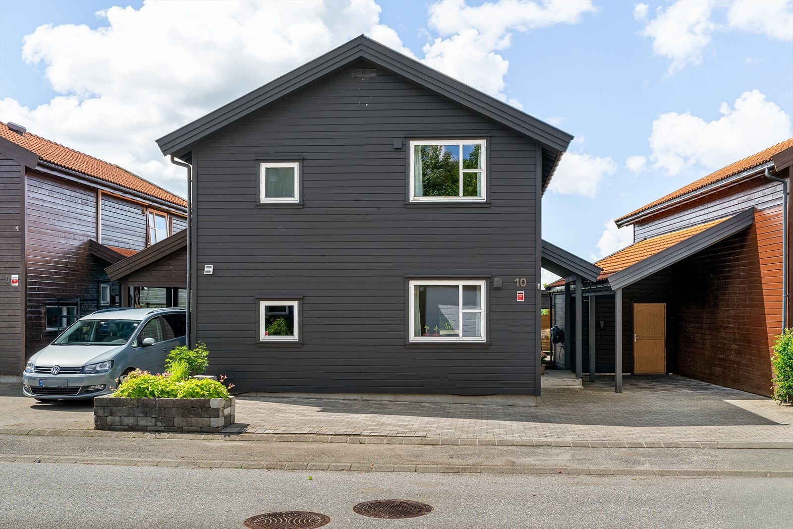 Egen carport med elbillader og skjermet inngangsparti bidrar til en funksjonell og innbydende helhet. Galleribilde