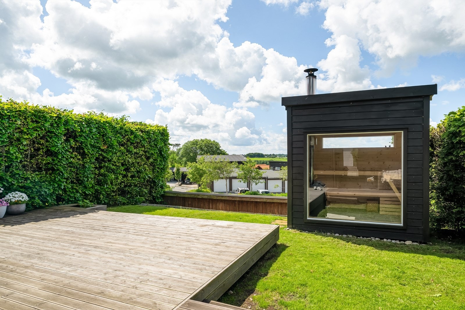 Frittstående badstue med moderne uttrykk og stort panoramavindu. Galleribilde