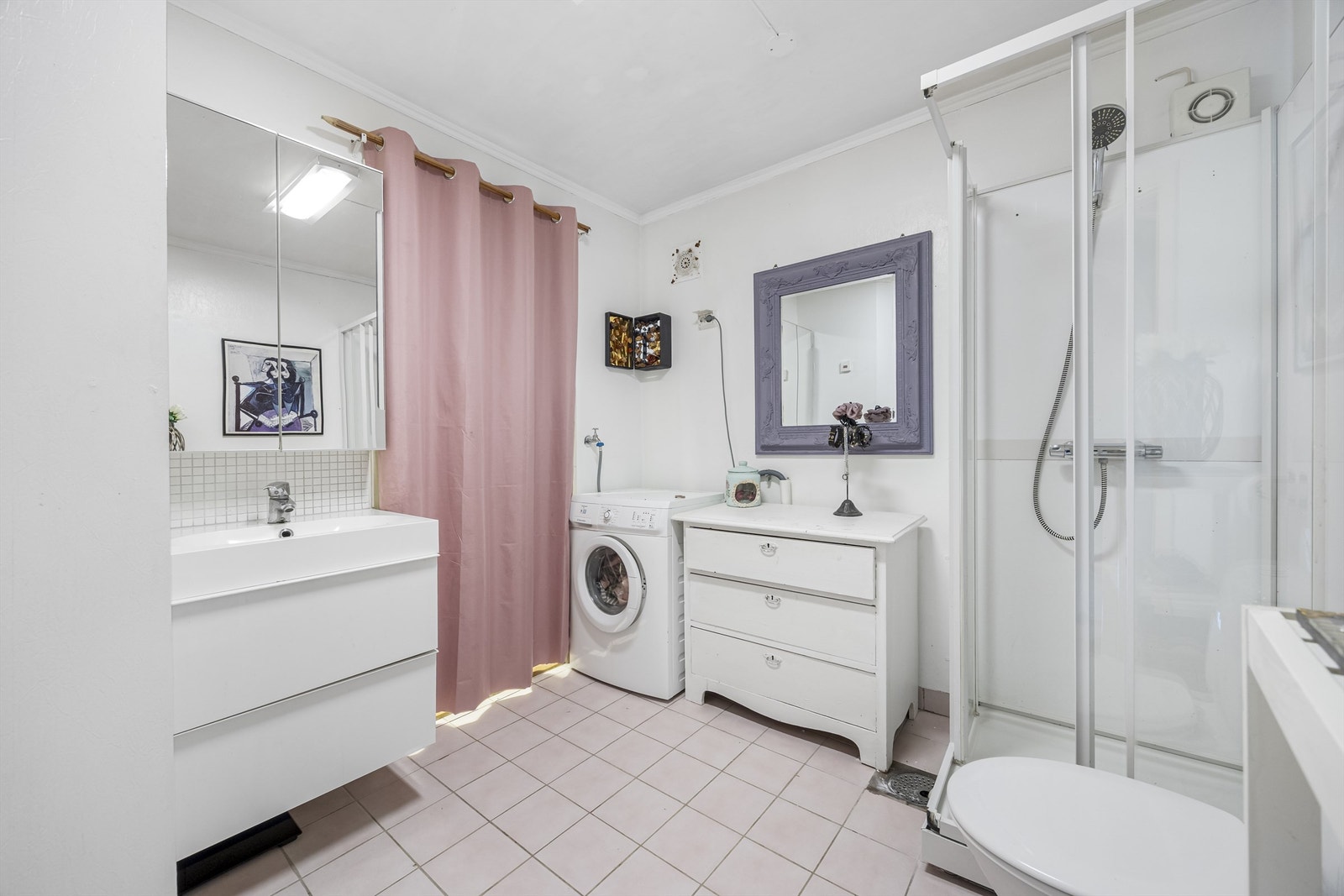 Badet er utstyrt med flislagt gulv med varmekabler, dusjkabinett, gulvstående toalett og opplegg for vaskemaskin. Galleribilde