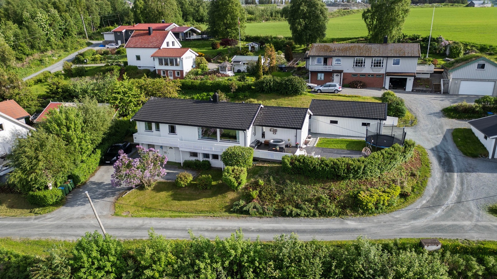 Dronebilde som viser boligen, tomten og de gode uteområdene. Galleribilde