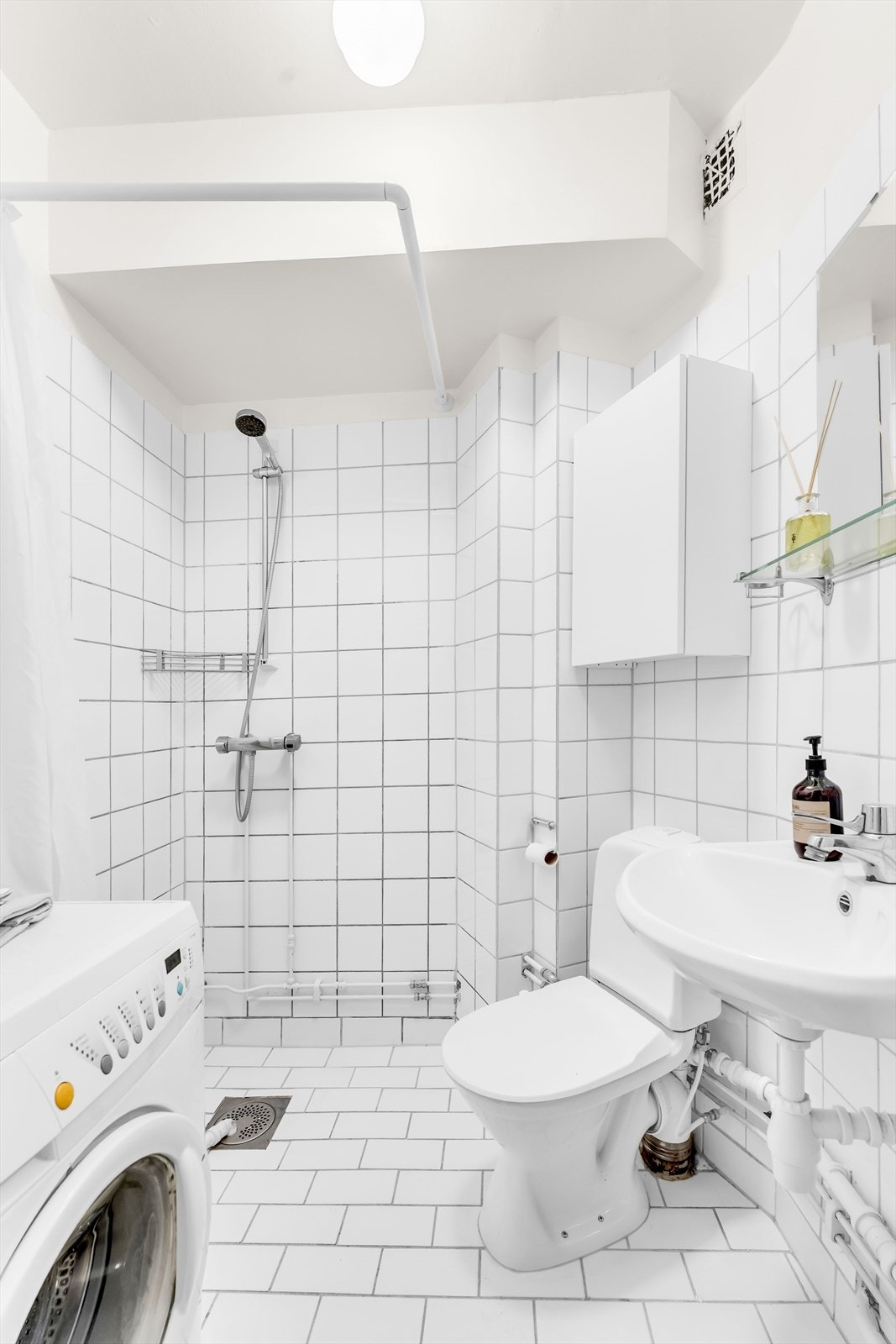 Praktisk bad med dusjsone, wc, servant og opplegg for vaskemaskin. Galleribilde