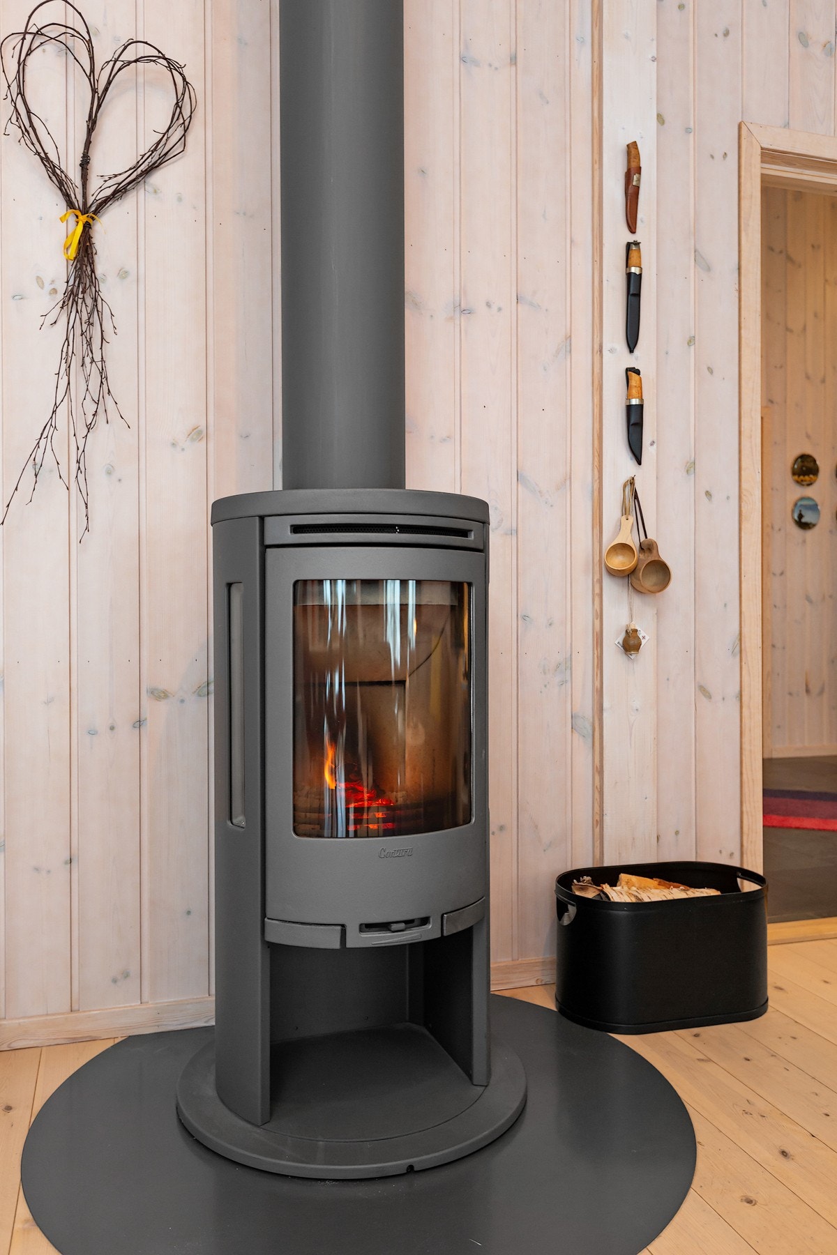 I midten av rommet er det plassert en moderne peis, som bidrar til både varme og hygge på kjølige dager. Galleribilde