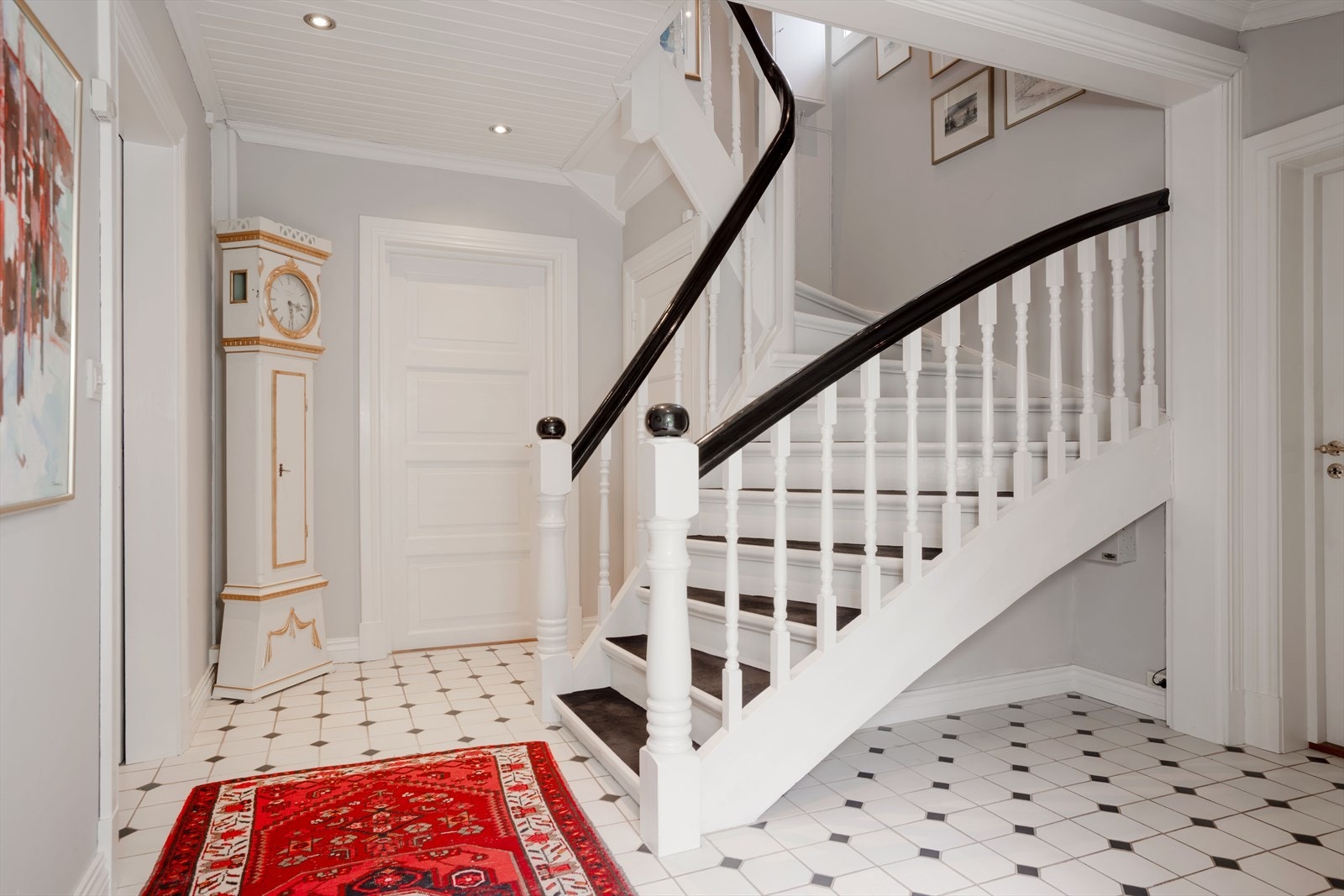 En romslig hall ønsker velkommen inn. Den originale tretrappen med teppe i trinnene forbinder etasjene. Galleribilde
