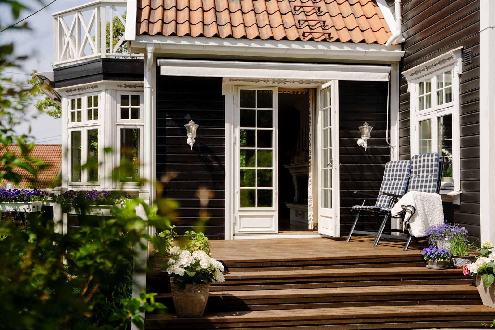 Fra stuen er det obbelfløyede glassdører til verandaen, med videre adkomst ned til den usjenerte og frodige hagen. Galleribilde