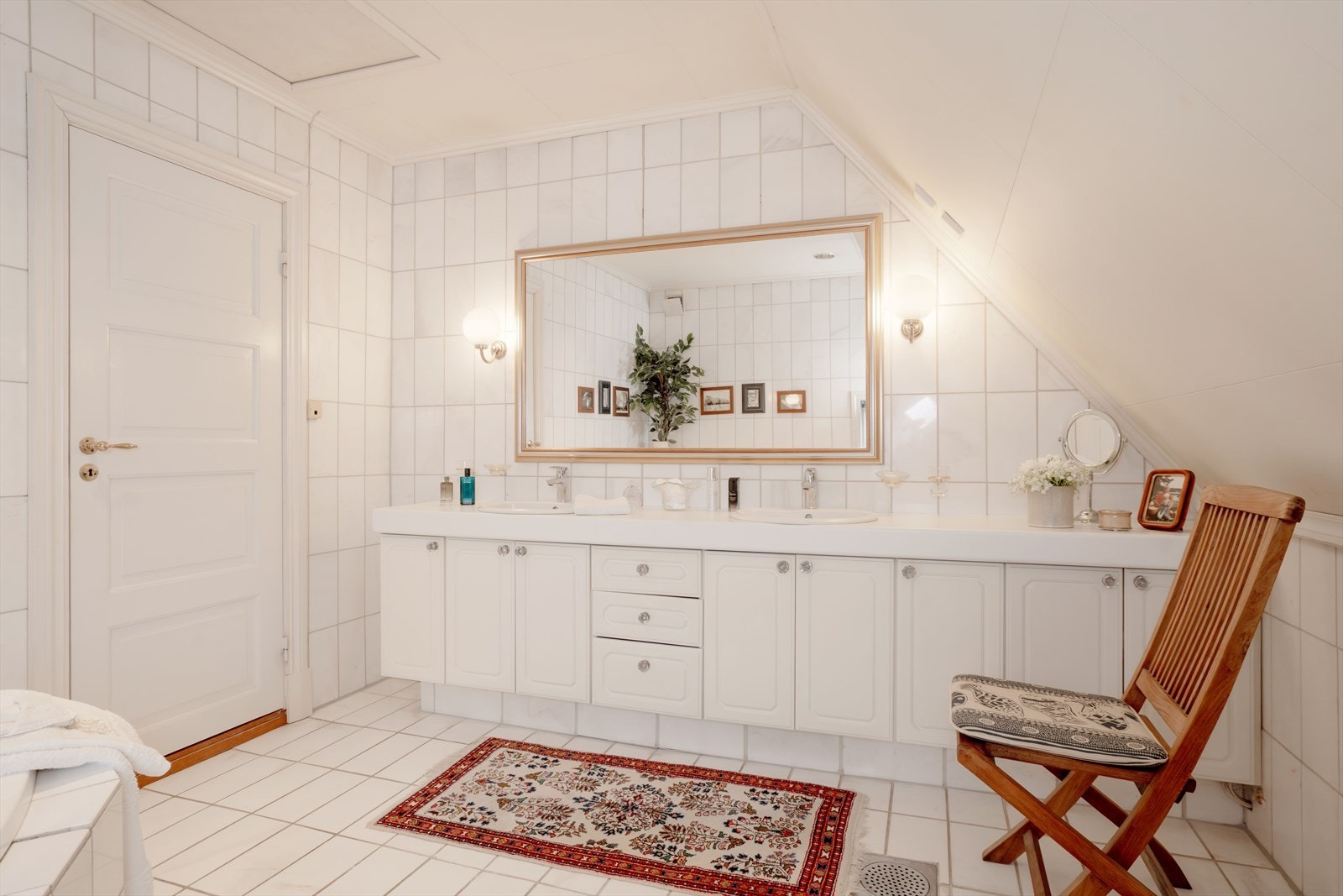 Romslig bad i 2. etasje med marmorfliser på gulv og vegger. Innredningen har to nedfelte servanter. Galleribilde