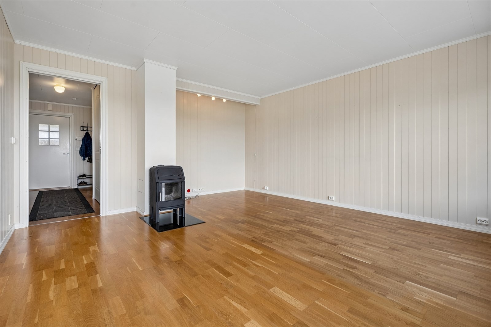 Stuen har parkett på gulvet og malte plater på veggene. Galleribilde