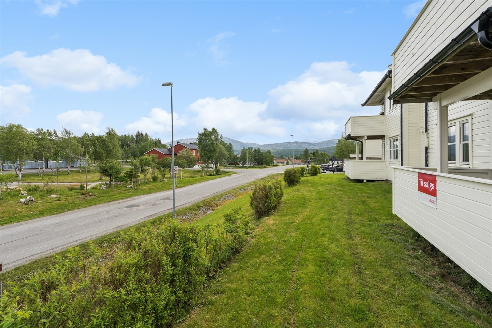 Borettslagets opparbeidede tomt har plen, prydbusker og gruslagt gårdsplass. Galleribilde
