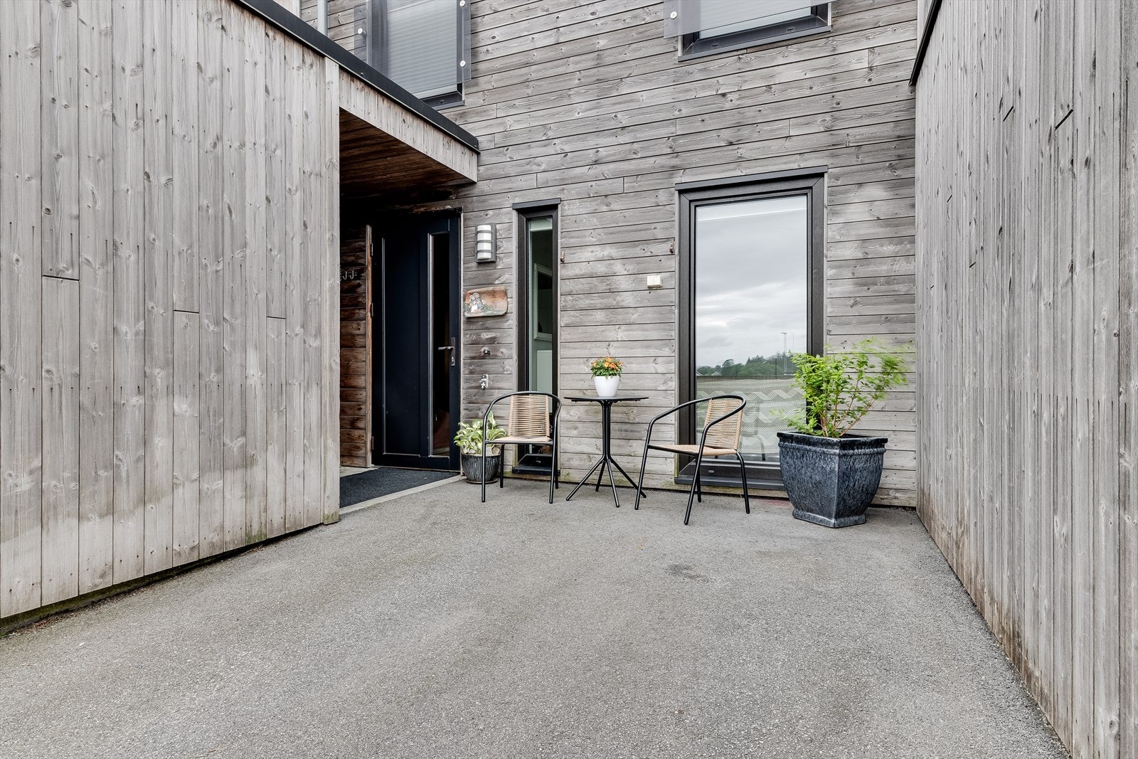 Egen biloppstillingsplass på asfaltert gårdsrom. Galleribilde