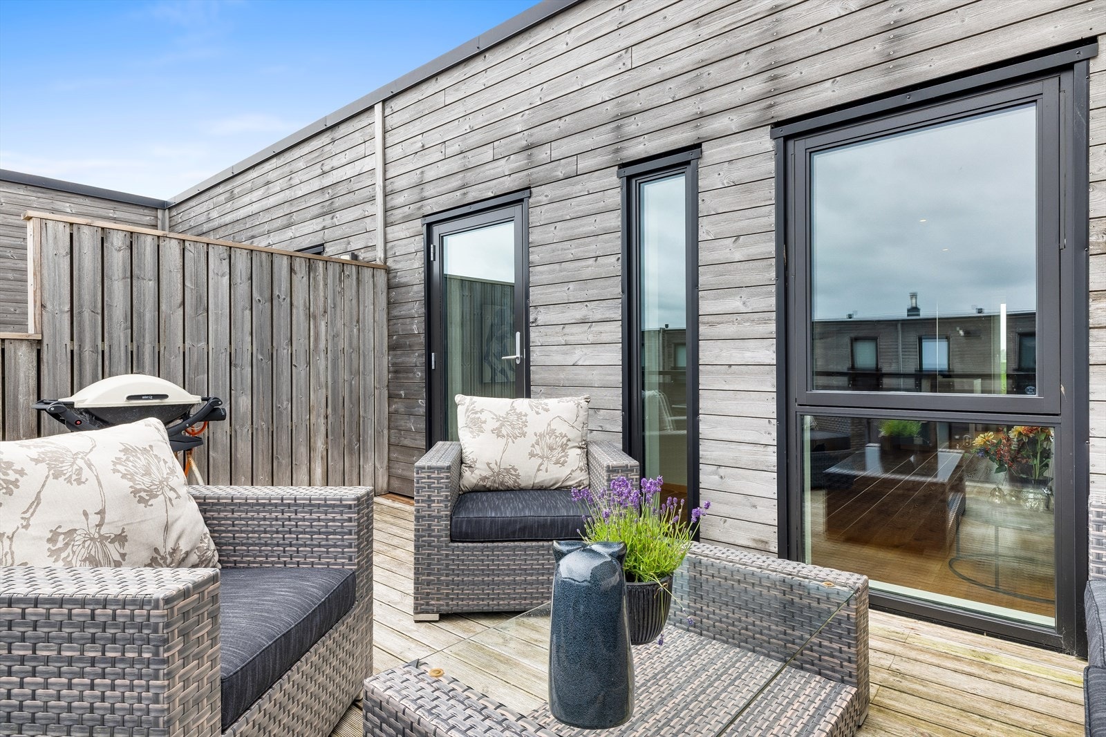 Balkongen er tekket med terrassebord og har rekkverk i glass. Galleribilde