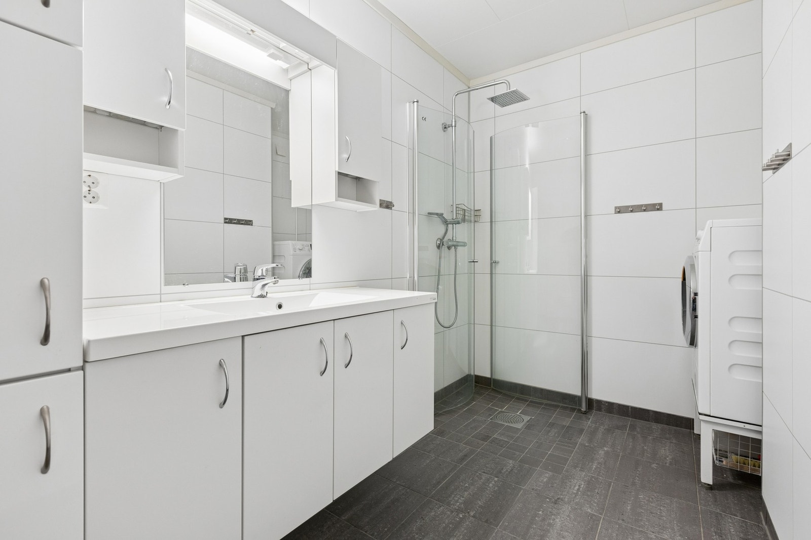 Hovedbadet i første etasje er helfliset og utstyrt med dusjhjørne og opplegg for vaskemaskin. Badet er fra 2017. Galleribilde