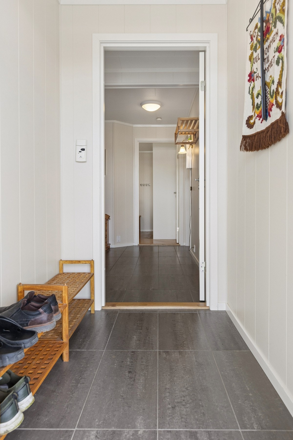 Entré med flislagt gulv og plass til oppbevaring av yttertøy. Galleribilde