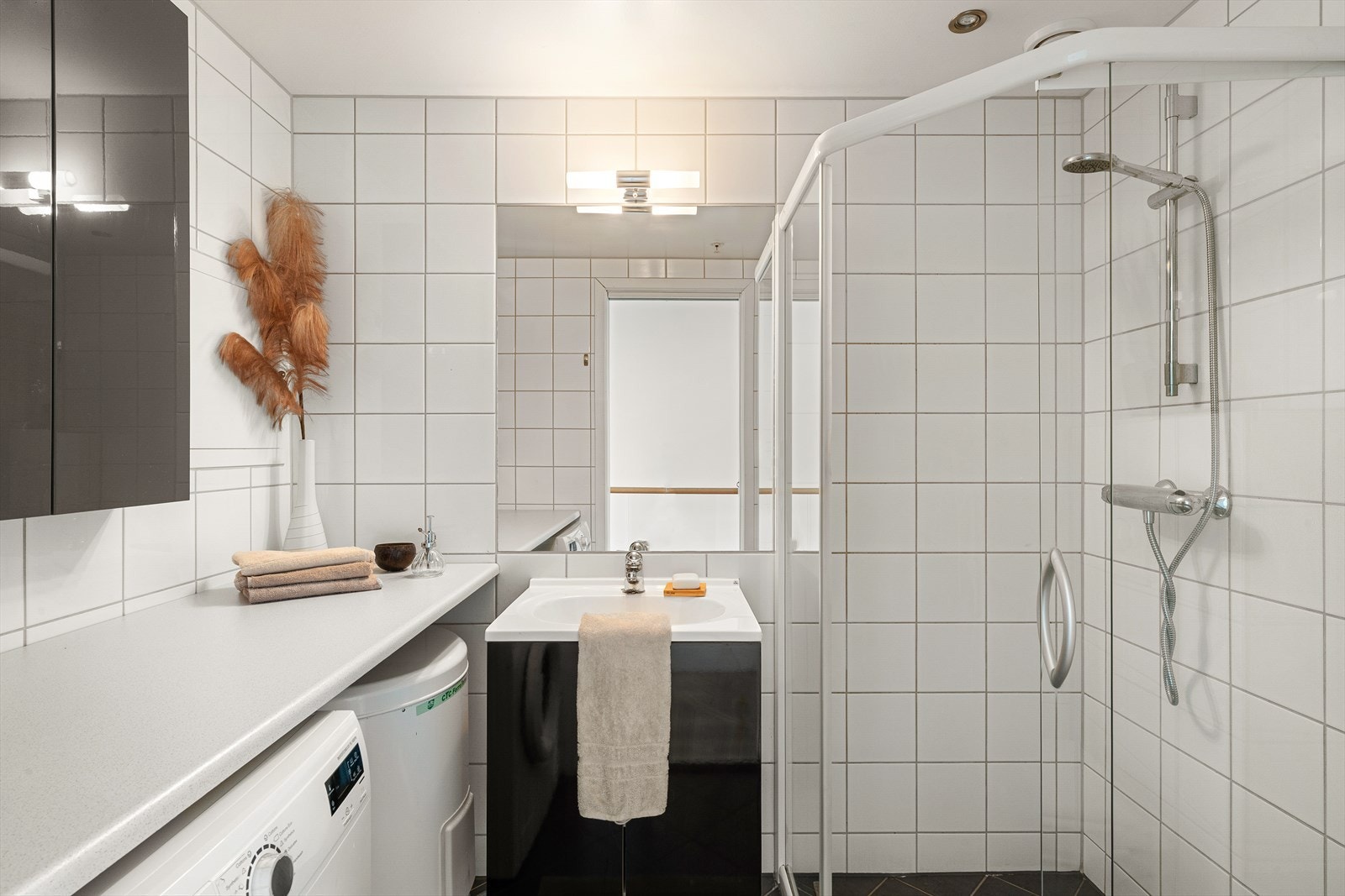 Flislagt bad med gulvvarme og opplegg for vaskemaskin. Galleribilde