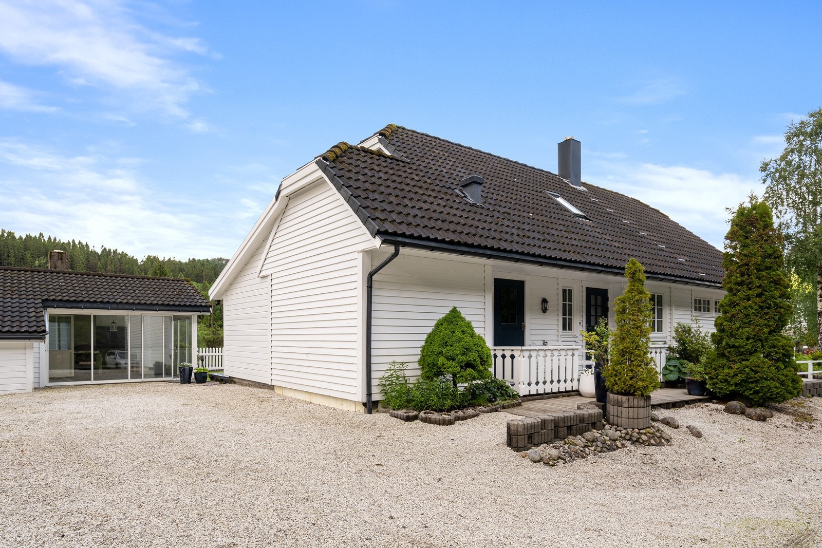 God parkering på siden av boligen. Her har man også en praktisk hagestue med bod. Galleribilde