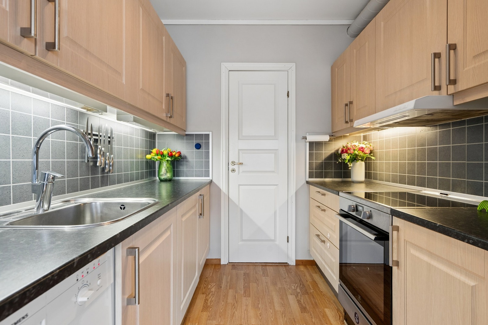 Kjøkkeninnredning med profilerte fronter, laminat benkeplate, oppvaskmaskin og stekeovn. Galleribilde