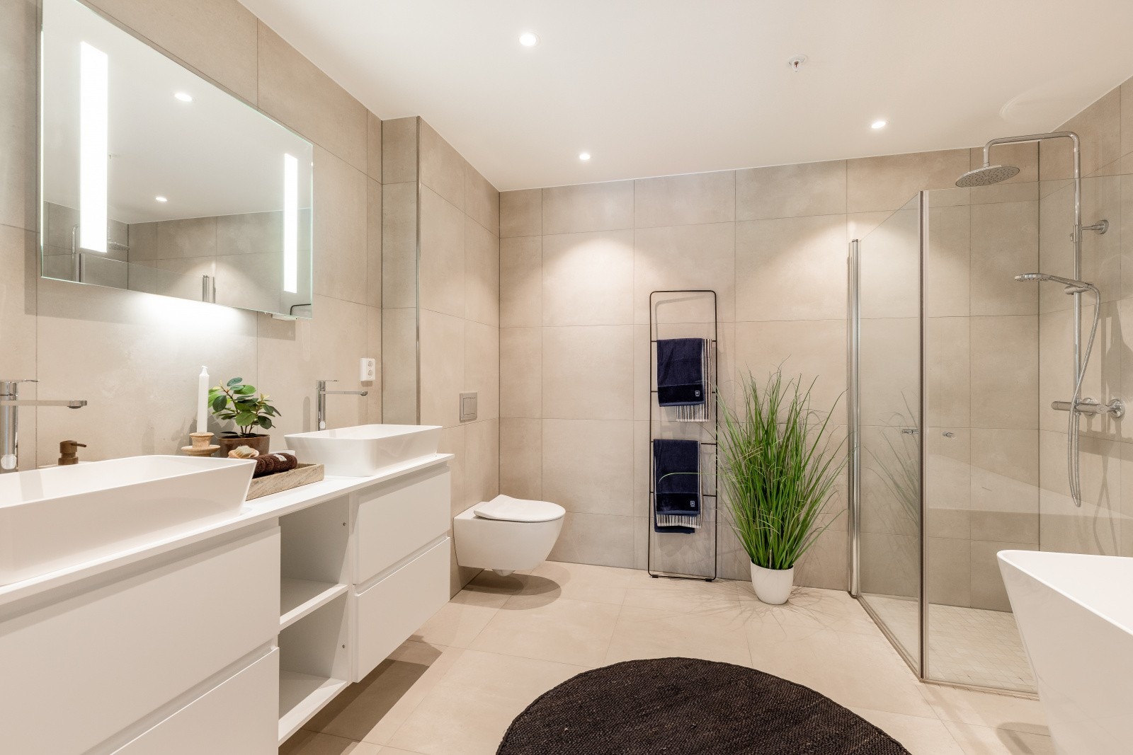 Leiligheten har to lekre bad med store, moderne fliser og en lun atmosfære som gir en deilig spafølelse på eget baderom. Hovedbadet er tilknyttet hovedsoverommet, mens gjestebadet ligger ved entrèen. Galleribilde