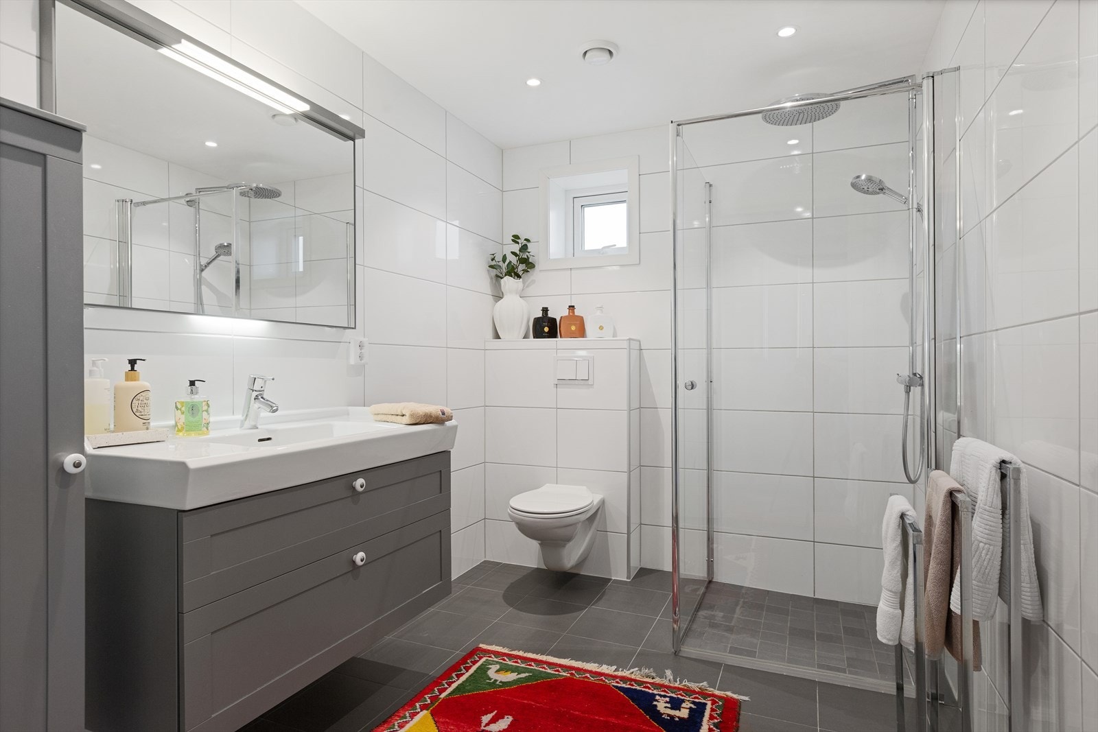 Badet i andre etasje har flislagt gulv med gulvvarme, vegghengt toalett og en nedsenket dusj med glassdører. Galleribilde