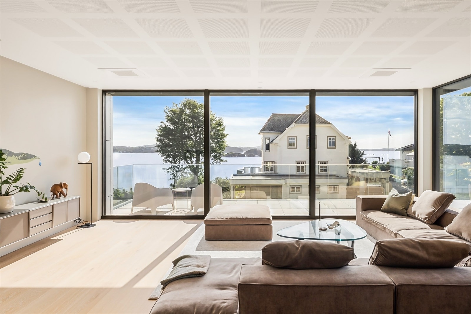 Skyvedører i glass åpner opp mot terrassen og visker ut skillet mellom inne og ute. Terrassen er vestvendt og her har man sol fra tidlig morgen til solnedgang. Galleribilde
