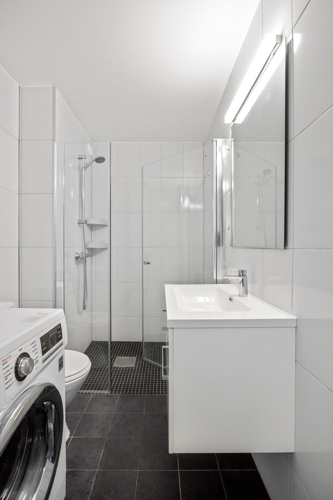 Baderommet | Lyst og flislagt bad med varmekabler i gulvet. Ifølge tidligere salgsoppgave er badet fra 2017. Galleribilde