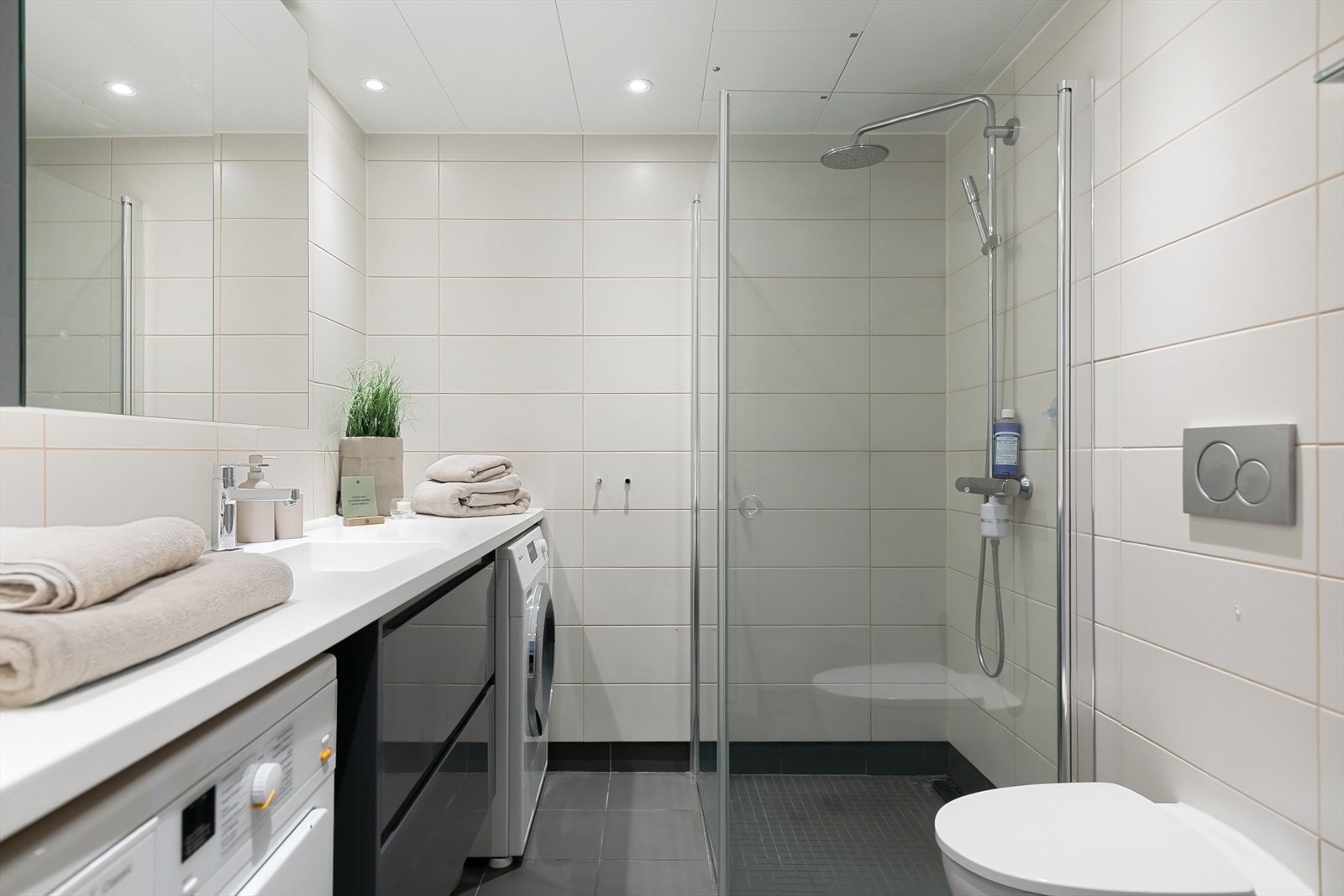Romslig og delikat baderom fra byggeår. Badet har tidsriktige farge- og materialvalg med flislagte overflater, gulvvarme og downlights i himling. Det er opplegg for vaskemaskin. Galleribilde