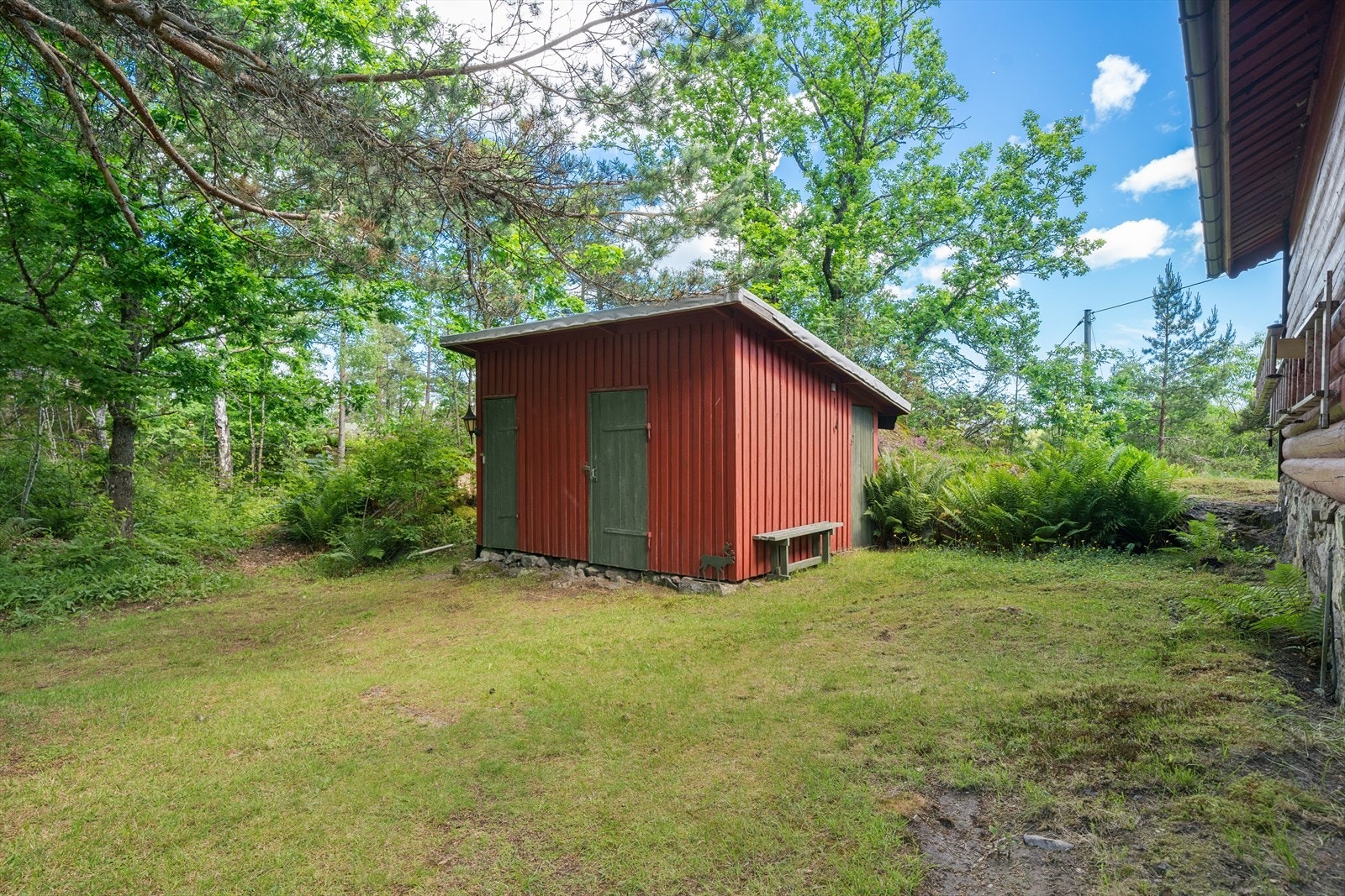 Eget vedskjul med utedo og boder på eiendommen. Galleribilde