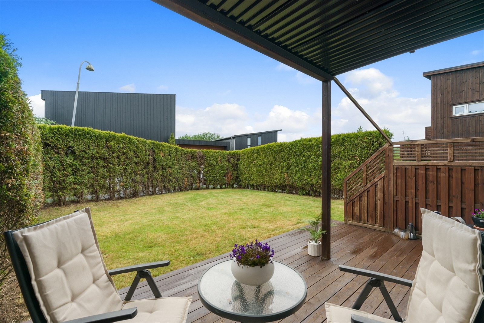 Overbygd terrasse med plass til sittegruppe og direkte adkomst til en romslig og lettstelt hage. Galleribilde