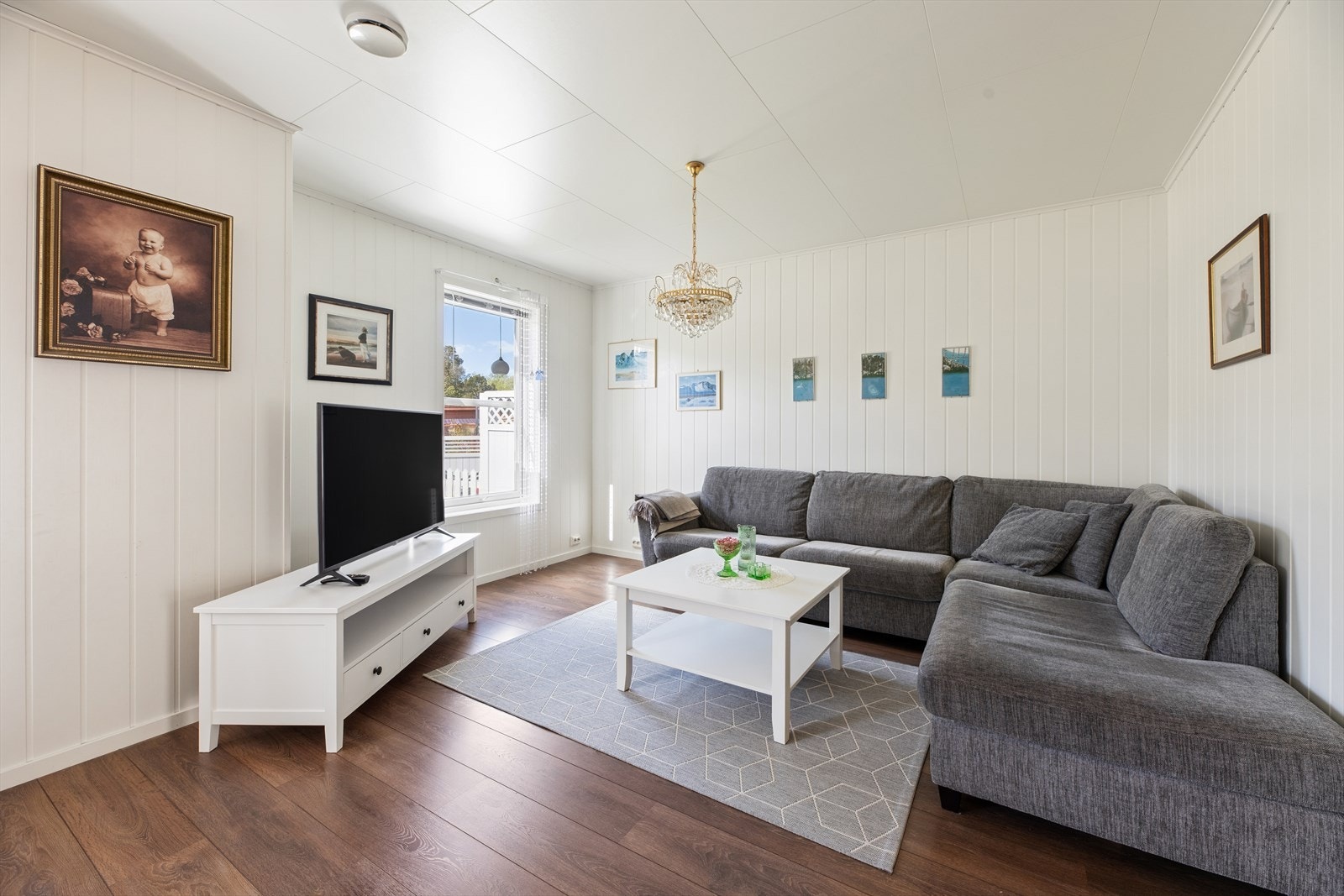 Sofagruppen med TV-krok har en svært god plassering ved vinduene, som gir rikelig med naturlig lys og skaper en lys og innbydende stue. Galleribilde
