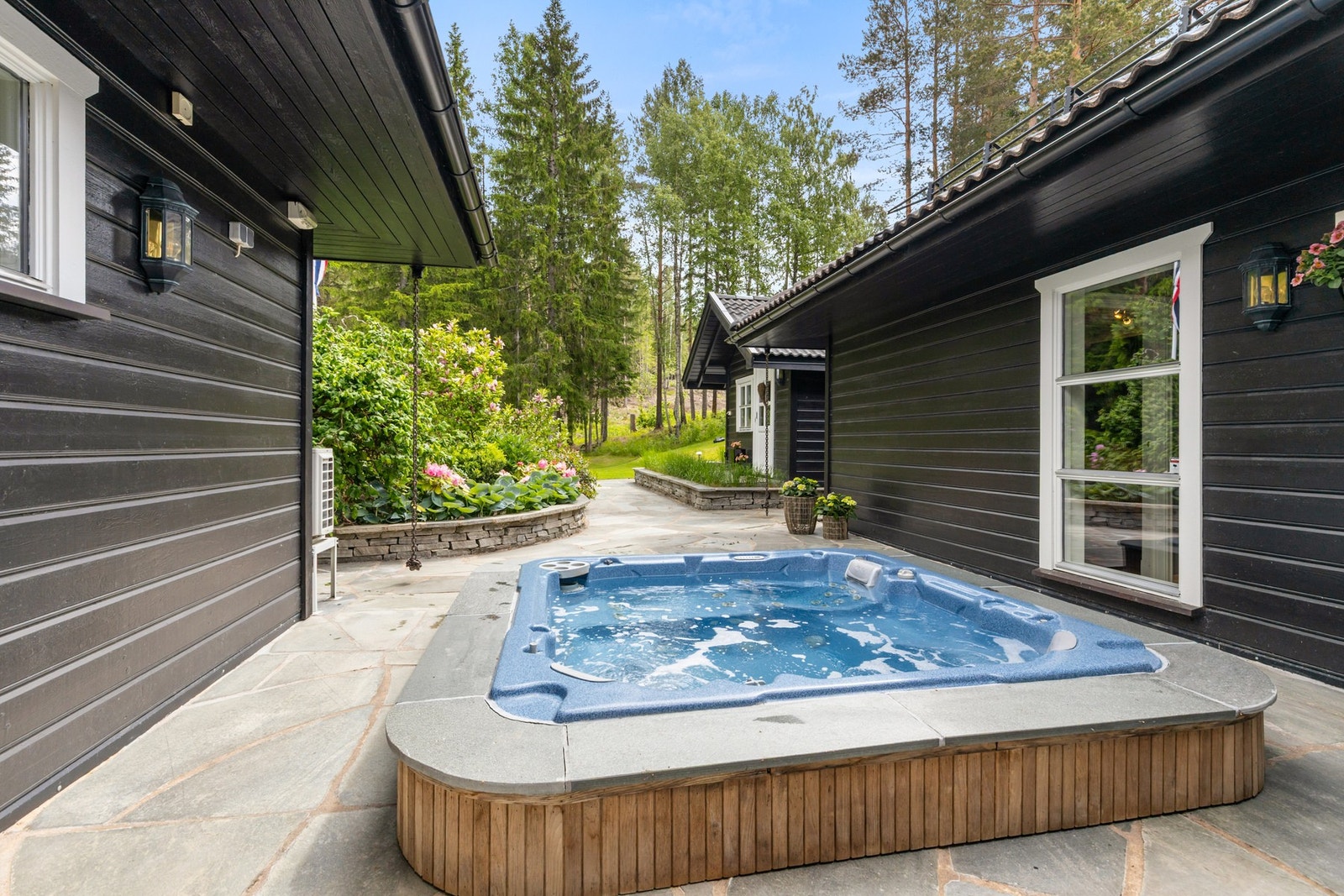 Det er flere store terrasser rundt boligen, hvorav én med nedsenket jacuzzi Galleribilde