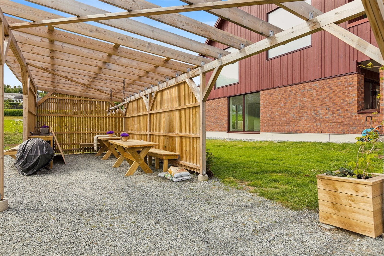 Sameiet disponerer en felles pergola med bord og benker for sosiale samkoster. Galleribilde
