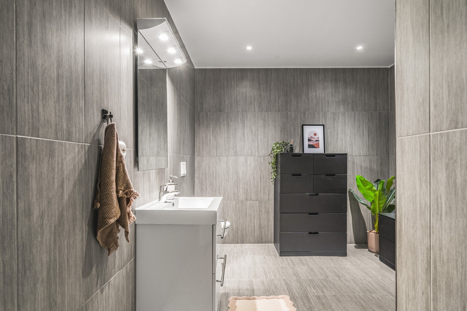 Badet i 1. etasje er romslig og delikat, med helflisede overflater og et moderne uttrykk Galleribilde