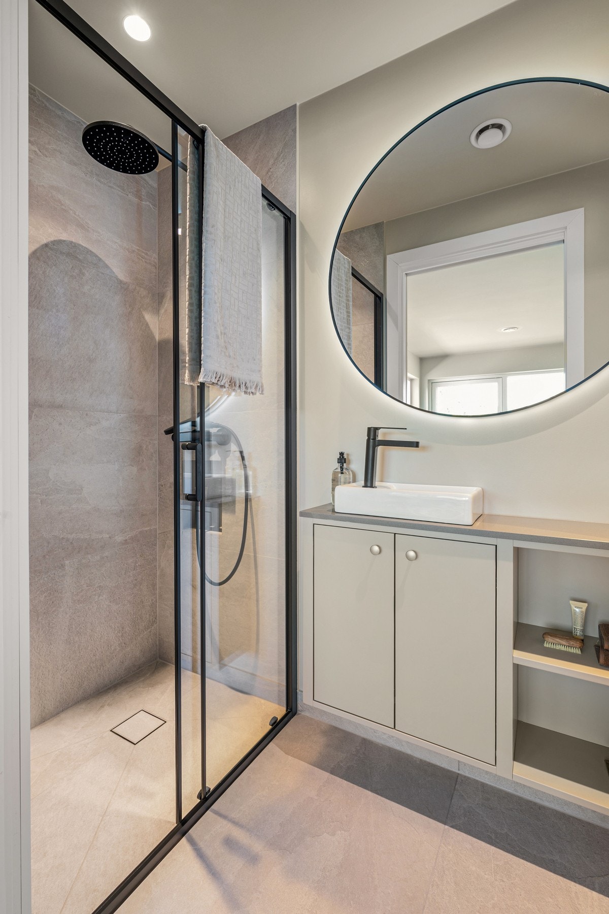 Dusjsonen har et moderne preg med sorte detaljer, glassvegger, regndusj og en praktisk innfelt nisje i veggen for oppbevaring av såpe og sjampo. Dette gir badet et elegant og gjennomført uttrykk. Galleribilde