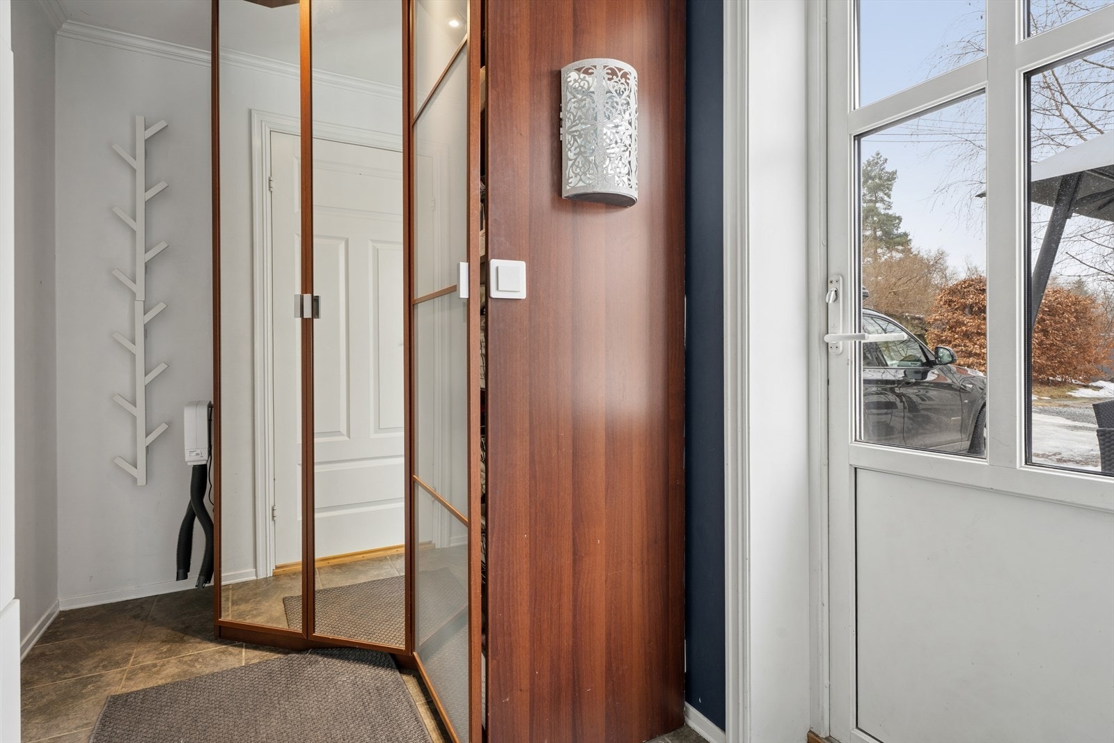 Velkommen inn. Entréen har et praktisk garderobeskap med speilfronter og downlights. Galleribilde