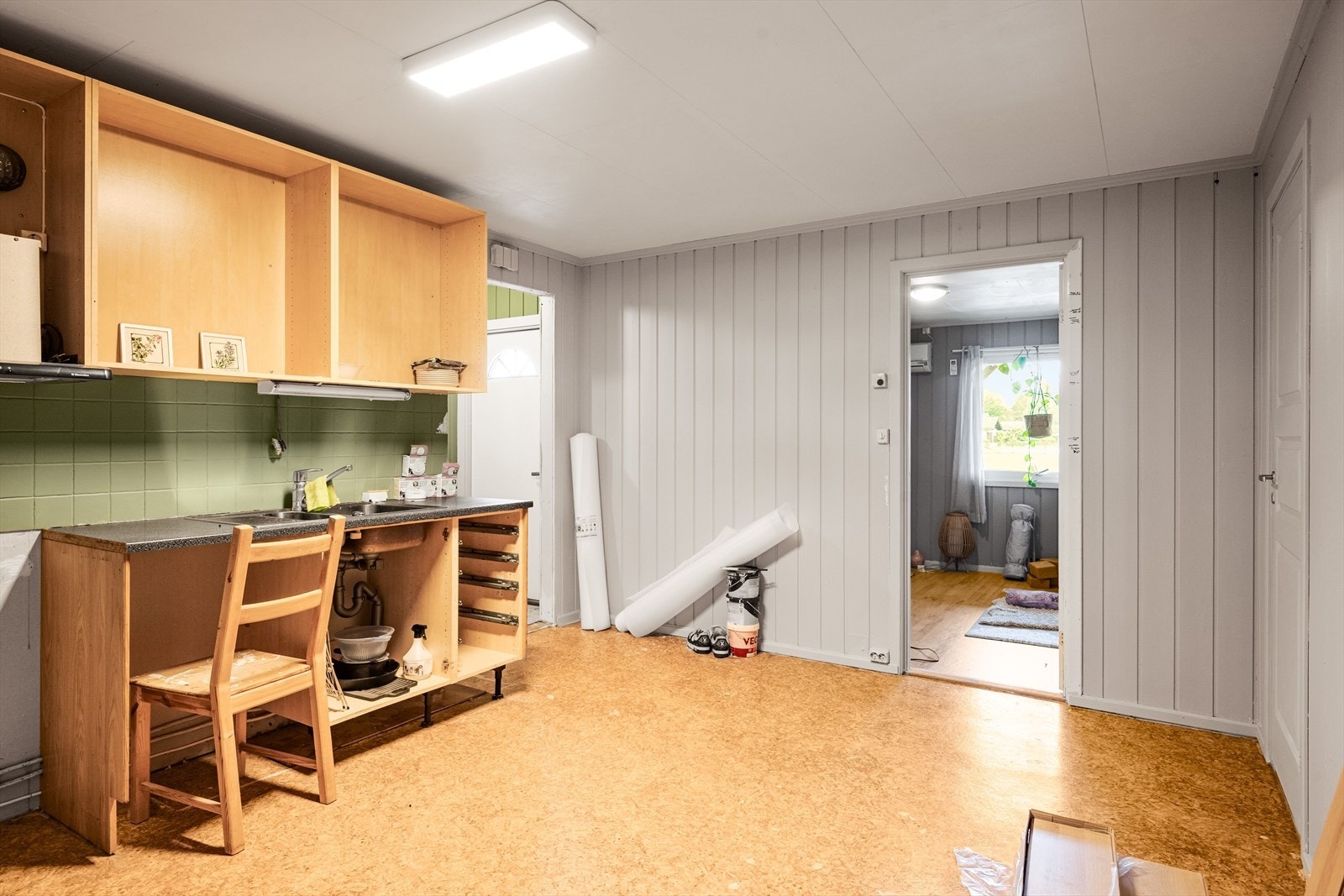 Enkel kjøkkeninnredning i underetasjen med laminert benkeplate og nedfelt servant. Det er noe gjenstående arbeider i hybeldelen. Galleribilde