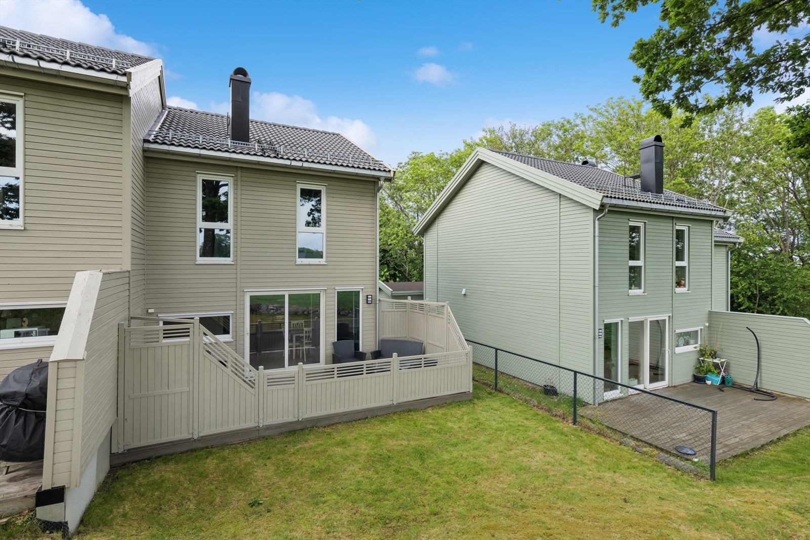 Romslig og solrik uteplass med plen og hyggelige sittegrupper - delvis skjermet terrasse med direkte adkomst fra boligen, perfekt for avslapning og sosiale sammenkomster. Galleribilde
