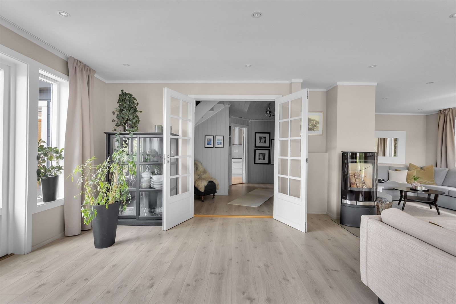 Tofløyede dører i tre med isolerglass åpner fra gangen inn til stuen. Galleribilde