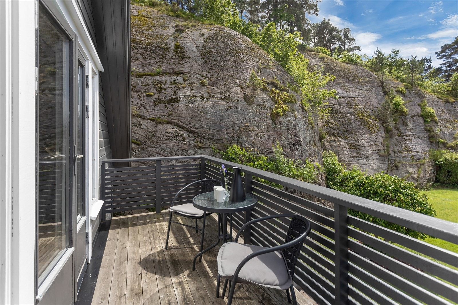 Verandaen er bygget i trykkimpregnert tre og har plass til en liten sittegruppe. Galleribilde