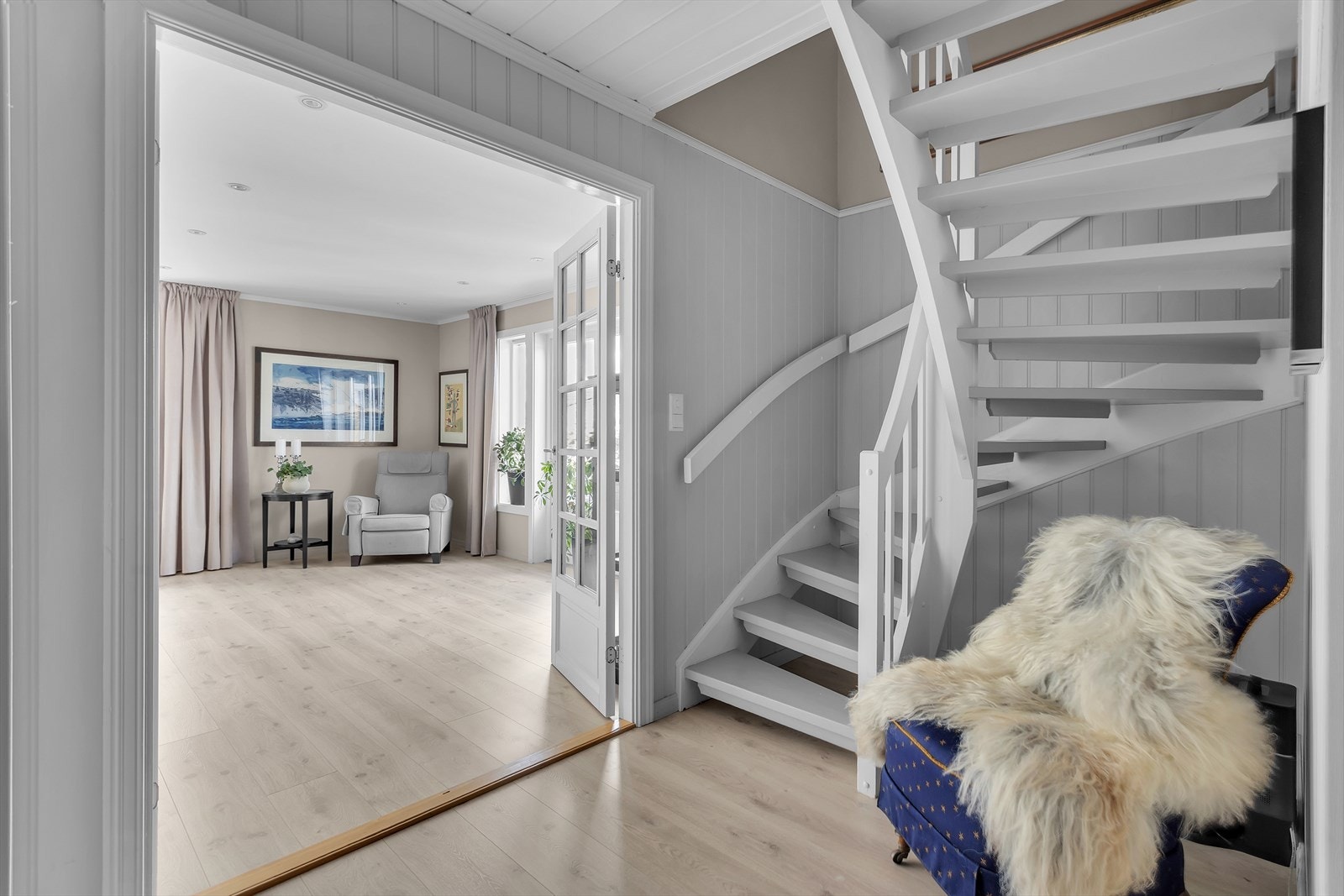 Den hvitmalte tretrappen med vanger og rekkverk av overmalt tre binder etasjene sammen. Galleribilde
