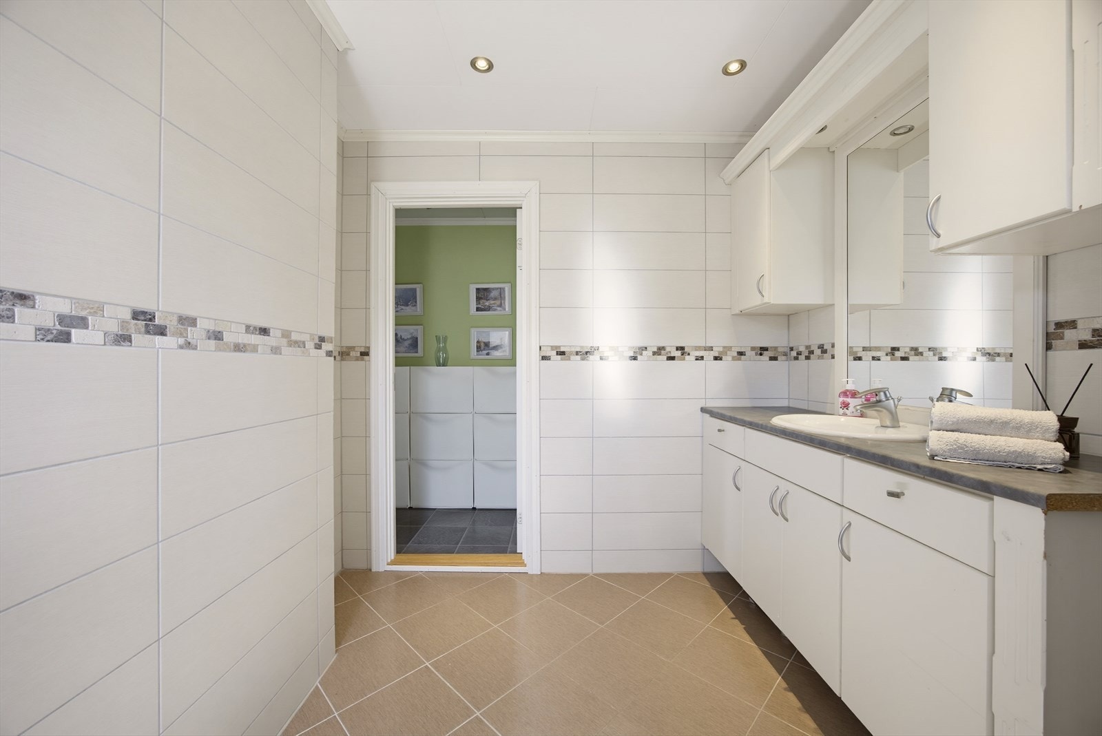 Badet er innredet med servantinnredning, dusjkabinett og toalett. Galleribilde