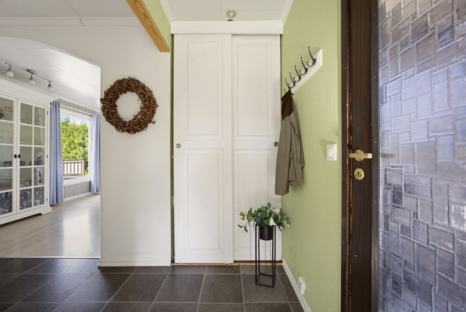 Fra entreen kommer man videre inn til gang med skyvedørsgarderobe. Galleribilde