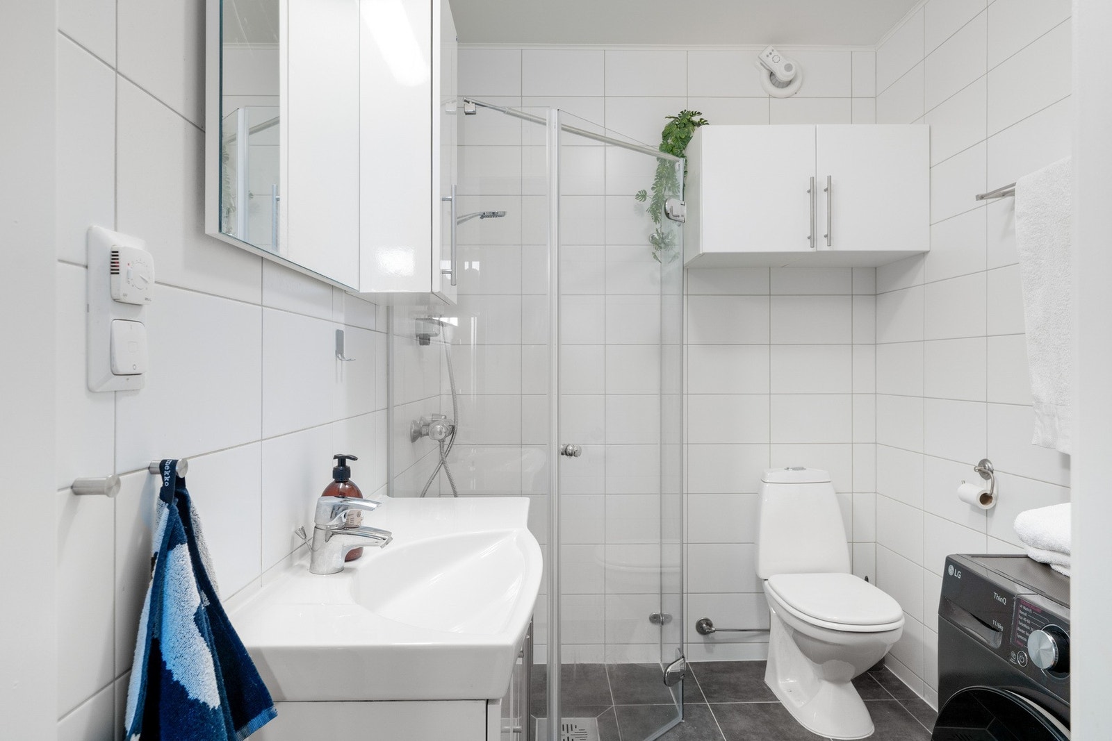 Badet er utstyrt med stor baderomsinnredning, toalett, dusjhjørne med innfellbare dusjdører og opplegg for vaskemaskin. Galleribilde
